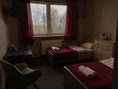 a small bedroom with two beds and a window at Szalowa Sport Arena in Szalowa