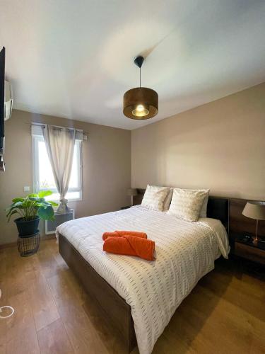 Un dormitorio con una cama con una toalla naranja. en Très bel appartement dans résidence avec piscine à 5min des plages de Villeneuve Loubet. en Villeneuve-Loubet