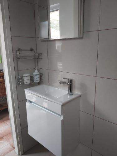 a white bathroom with a sink and a window at Apartment Jasenka in Brna