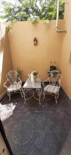 2 sillas y una mesa en el patio en Giara Aparts. en Villa María
