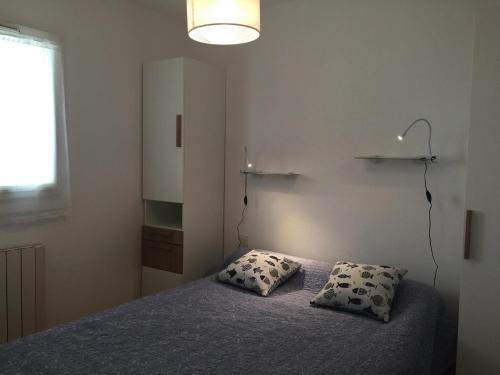 une chambre avec un lit avec deux oreillers dessus dans l'établissement Appartement rénové bord de plage avec balcon et parking à Jard-sur-Mer - FR-1-336-79, à Jard-sur-Mer