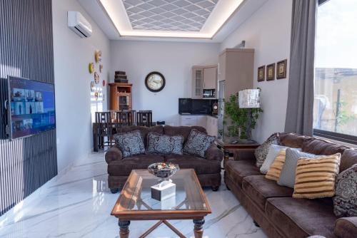a living room with two couches and a coffee table at Adam's Luxury Villa DeadSea in Sowayma