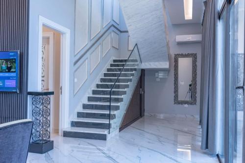 a staircase in a building with white walls and marble floors at Adam's Luxury Villa DeadSea in Sowayma