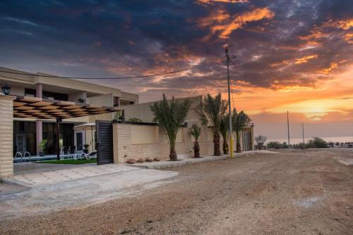 an empty road in front of a house with a sunset at Adam's Luxury Villa DeadSea in Sowayma