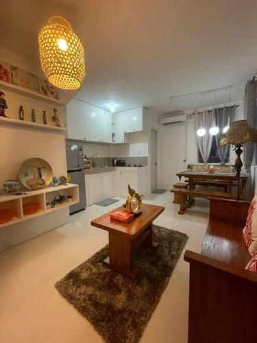 Lily’s Homestay في بوتوان: غرفة معيشة مع طاولة ومطبخ
