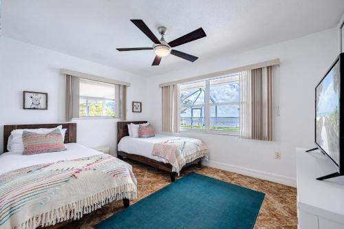 a bedroom with two beds and a ceiling fan at Heated Pool, Ping Pong Table, Sleeps 10 - Villa Sunset Riverhouse in Cape Coral