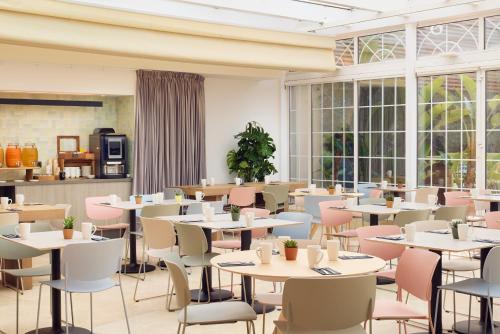 a restaurant with tables and chairs and windows at INNSiDE by Meliá Barcelona Apolo in Barcelona