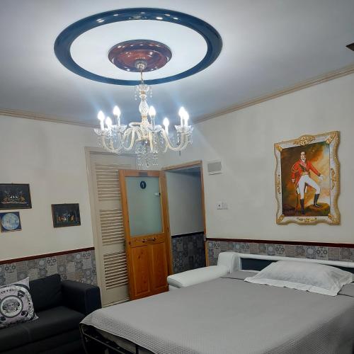a bedroom with a bed and a chandelier at 79A Valletta Accommodation in Valletta