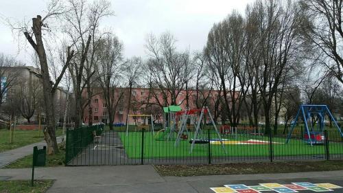 um parque infantil num parque com árvores e um edifício em Szava Angel em Budapeste
