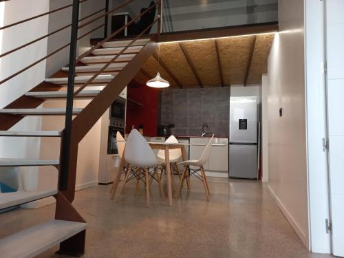 a kitchen and dining room with a staircase and a table and chairs at Loft Nou Benicalap in Valencia