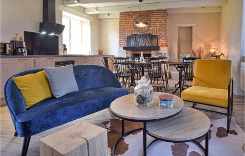 un salon avec un canapé bleu et une table dans l'établissement Cozy Home In Saint-Brice-De-Landell, à Saint-Brice-de-Landelles