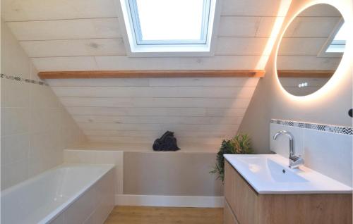 uma casa de banho com uma banheira, um lavatório e um espelho. em Stunning Home In Saint-brice-de-landell With Wifi And 3 Bedrooms em Saint-Brice-de-Landelles