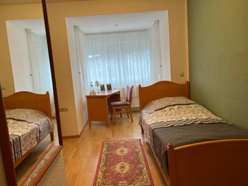 a bedroom with two beds and a table and a mirror at Landhaus Pusteblume in Quedlinburg