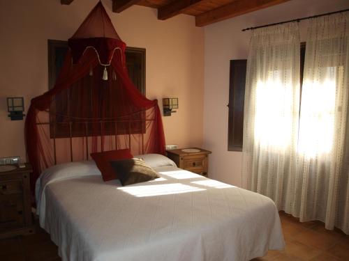 una camera da letto con due letti e una finestra di Casa Rural El Olivo a Guijo de Granadilla