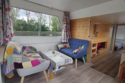 ein Wohnzimmer mit einem Sofa und einem Tisch in der Unterkunft Libéllule péniche nuit insolite in Briennon