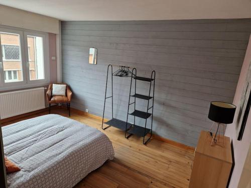 een slaapkamer met een ladder, een bed en een stoel bij Maison familiale in Duinkerke
