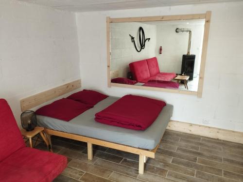 Bett in einem Zimmer mit einem roten Stuhl und einem Spiegel in der Unterkunft Best Price #1 "L'ANN'EXE" x4 people in Orchamps-Vennes