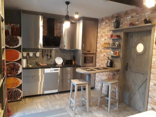 a kitchen with stainless steel appliances and a brick wall at Olivia apartament przy deptaku in Szczawno-Zdrój