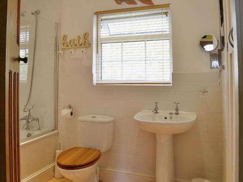a bathroom with a toilet and a sink at High Moor Cottage in Dufton