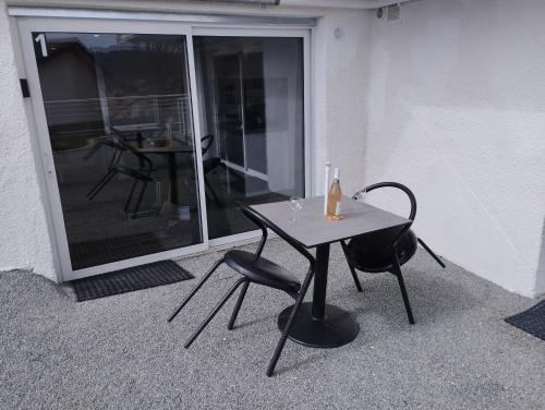 una mesa y dos sillas sentadas junto a una ventana en Best Price #1 "L'ANN'EXE" x4 people, en Orchamps-Vennes