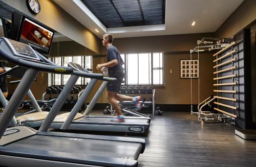 a man walking on a treadmill in a gym at L'Hotel PortoBay São Paulo in Sao Paulo