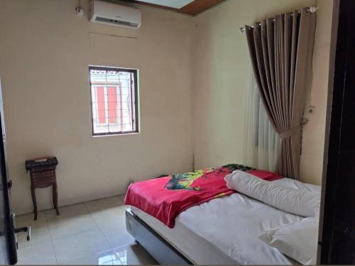 1 dormitorio con 1 cama en una habitación con ventana en Homestay Malioboro by Oemah Tompeyan en Jetis