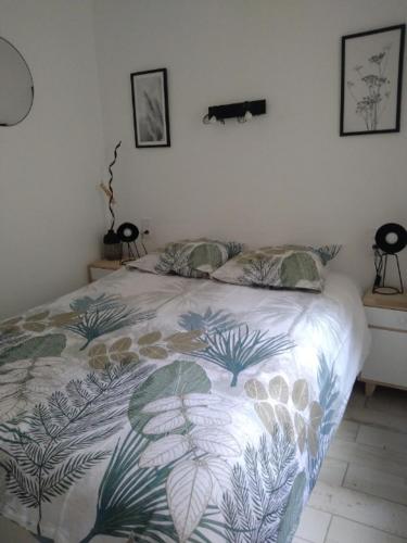 une chambre avec un lit avec une couette fleurie dans l'établissement Appartement spacieux proche de la mer, à Banyuls-sur-Mer