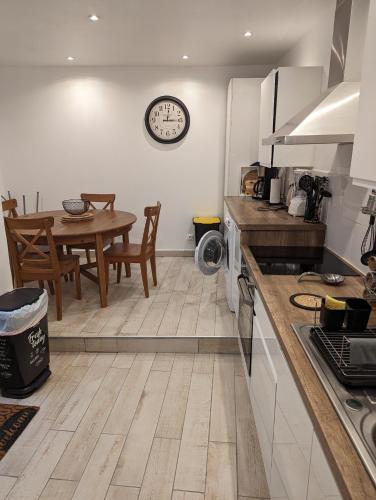 une cuisine avec une table et une horloge au mur dans l'établissement Appartement spacieux proche de la mer, à Banyuls-sur-Mer