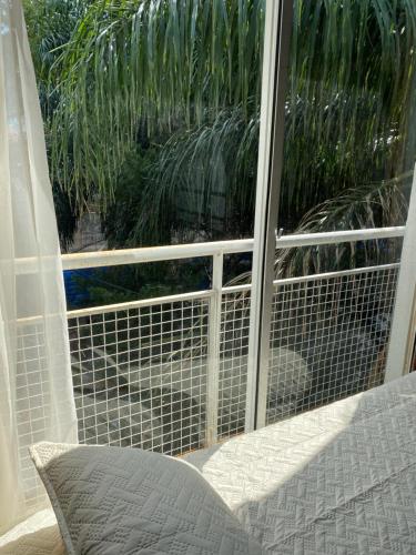 una ventana corredera de cristal con vistas al jardín en Apart Bosch House en Vicente López