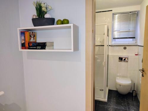 een badkamer met een toilet en een plank met appels erop bij Ferienwohnung An der Korkeiche in Rinnthal