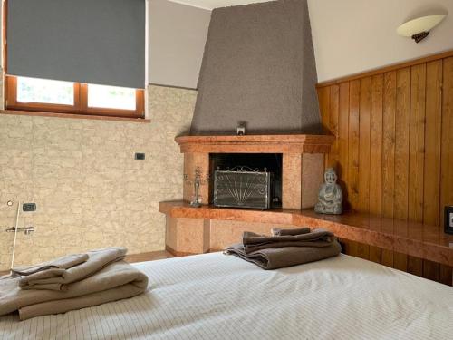 een slaapkamer met een bed en een open haard bij Green Woods in Verona