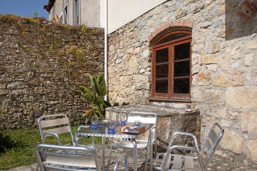 a table and chairs in front of a stone building at Silver coast villa in Alcobaça