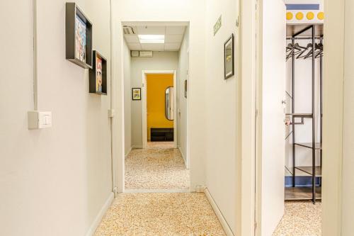 a hallway with white walls and a yellow door at Game Rooms Experience in Livorno