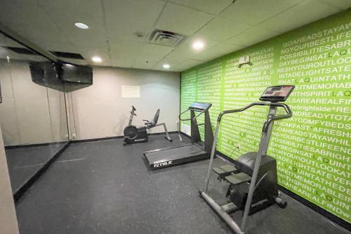 a gym with two exercise bikes and a green wall at OYO Townhouse Jackson - Ridgeland in Jackson