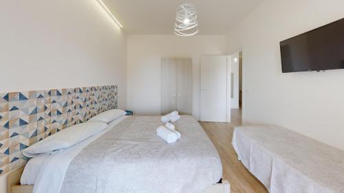 a bedroom with two beds and a flat screen tv at Accòmodati - Camere e Appartamenti in Marina di Gioiosa Ionica