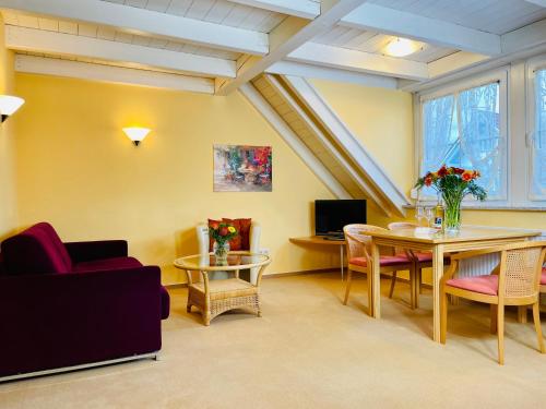 a living room with a couch and a table and chairs at Im Winkel Appartements und Zimmer in Langenargen