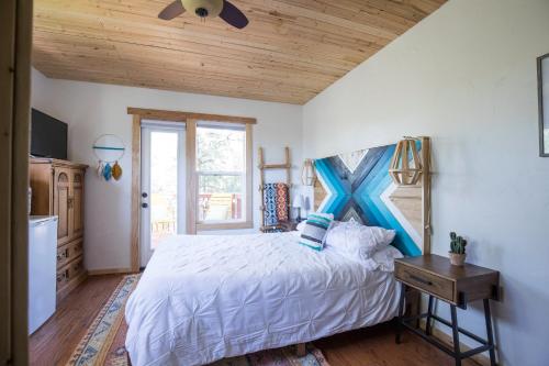 ein Schlafzimmer mit einem großen Bett und einer Holzdecke in der Unterkunft Pueblo Canyon Inn in Los Alamos