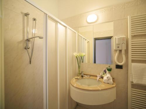 een badkamer met een wastafel en een douche bij Hotel Levante in Rimini