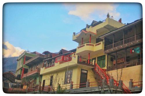 a large building with balconies on top of it at Kullu Manali Homestay in Kulu