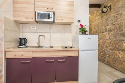 a small kitchen with a refrigerator and a microwave at Tamaria in Split