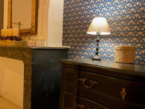 une lampe assise au-dessus d'une commode dans une pièce dans l'établissement Le Chai des Tuileries, à Montagnac
