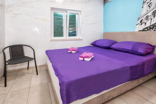 a purple bed with two pink pillows on it at Tamaria in Split