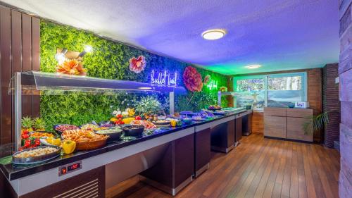 a buffet line with food in a restaurant at Hôtel du Poète in Aix-les-Bains