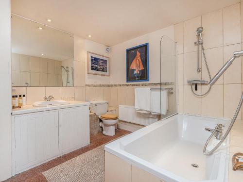 a bathroom with a tub and a toilet and a sink at Lower Mill in Dartmouth