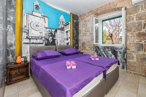 een slaapkamer met een paars bed met Hello Kitty kussens erop bij Tamaria in Split