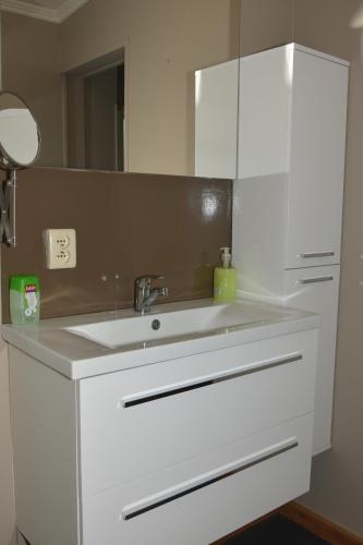 a white bathroom with a sink and a mirror at Kiefhoekhuisje in Hechtel-Eksel