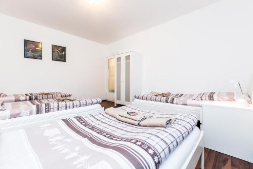 three beds in a room with white walls at Ferienwohnung Köln Stammheim in Cologne