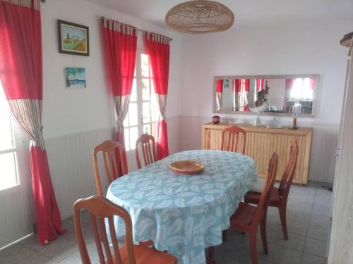 a dining room with a blue table and chairs at Case Tortue - chambres chez l'habitant - 3 étoiles in Les Avirons