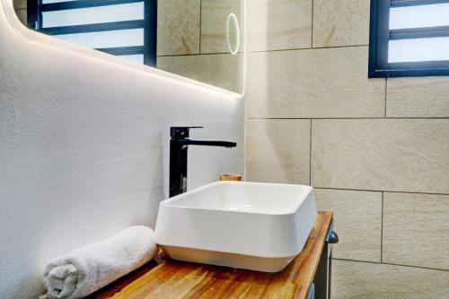 a bathroom with a white sink on a wooden counter at Le Yang - T3 Cosy & moderne à Saint Denis in Saint-Denis