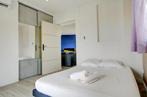 een slaapkamer met een wit bed en handdoeken bij Le Yang - T3 Cosy & moderne à Saint Denis in Saint-Denis